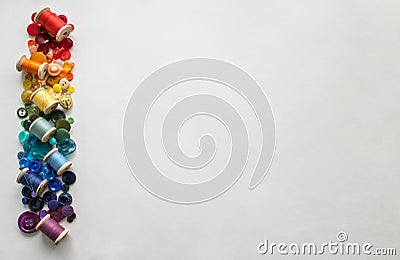 Buttons, colorful threads, pins laid out rainbow spectrum on a white background. Copy space Stock Photo