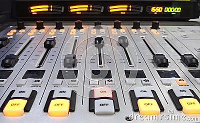 Buttons, volume levels, switches on the audio mixer control panel working on a table at a radio studio Stock Photo