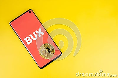 Bux icon on phone with Bitcoin on yellow background Stock Photo