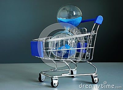 Buy time concept. Shopping cart and hourglass Stock Photo