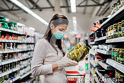 Buyer wearing a protective mask.Shopping during the pandemic quarantine.Nonperishable smart purchased household pantry groceries Stock Photo