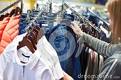 Buyer woman chooses jeans clothes in store Stock Photo