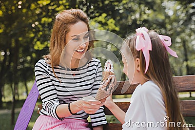 Caring mother buying ice cream for her nice pleasant child Stock Photo