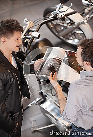 Buying a motorcycle. Top view of cheerful young sales executive Stock Photo