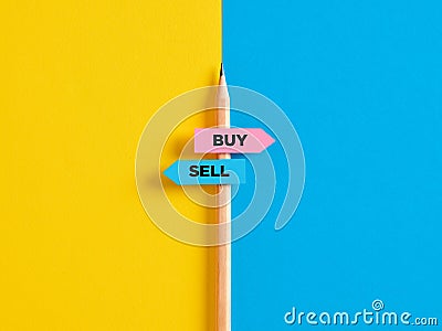 Buying or selling choice or decision. Pencil with direction indicator stickers showing the different decision paths to buy or to Stock Photo