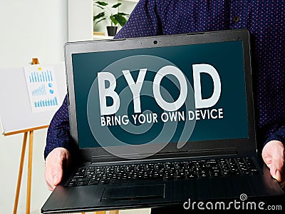 BYOD bring your own device. Man holds a laptop in his hands. Stock Photo