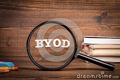 Byod concept. Magnifying glass with text on wooden office table Stock Photo