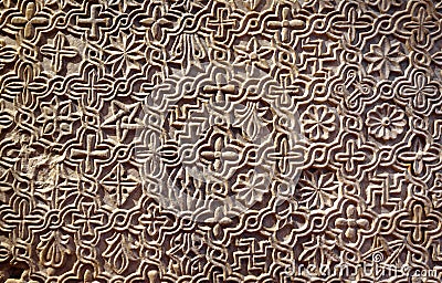 Byzantine patterned ornament carved in stone wall, ancient texture background, detail of interior with geometric relief Stock Photo