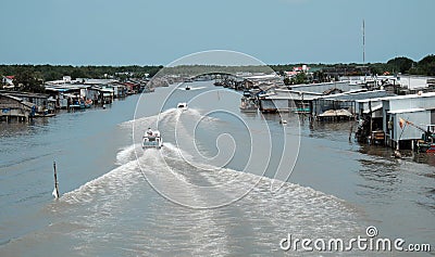 Ca Mau riverside residential with motor boat Editorial Stock Photo