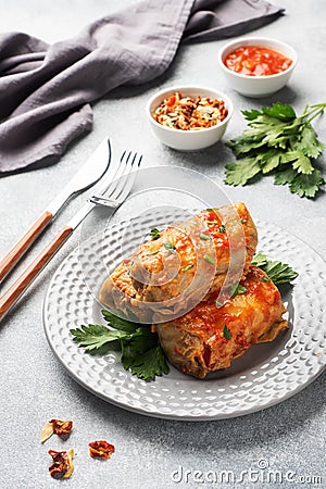 Cabbage rolls with beef, rice and vegetables on the plate. Stuffed cabbage leaves with meat. Gray concrete table Stock Photo