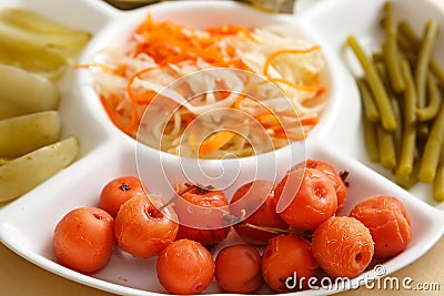 Cabbage, soaked cherries, garlic stalks green tomatoes on a plate Stock Photo