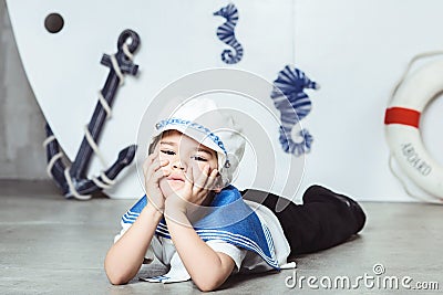 Cabin boy lying in front of stylized ship Stock Photo