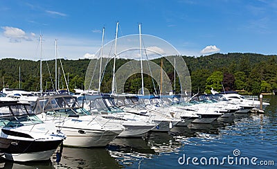 Cabin cruiser boats in a row on a lake with beautiful blue sky in summer Stock Photo