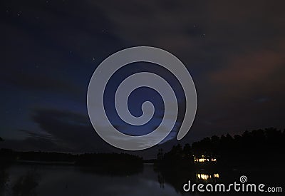 Cabin on the lake at night with the stars Stock Photo
