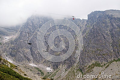 Cabin lift to the mountain. Mountain landscape in High Tatry. Chairlift at the ski resort in a cloud. Ski lift, cable car cabin in Stock Photo
