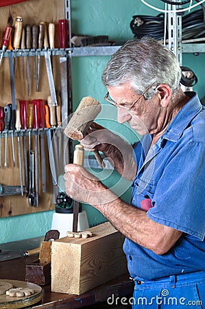 Cabinetmaker carving wood with a chisel and hammer Stock Photo