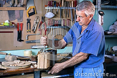 Cabinetmaker carving wood with clamp in workbench Stock Photo