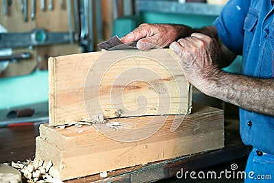 Cabinetmaker working with sandpaper in the bench in garage at ho Stock Photo