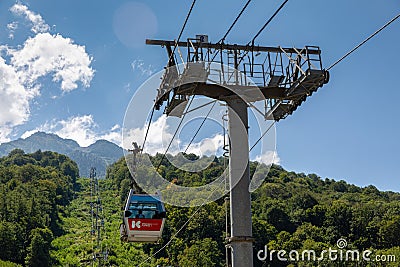 Cable car lifts tourists to the mountains in the year-round resort of Krasnaya Polyana. Krasnodar region, Sochi, Mountain Carousel Editorial Stock Photo