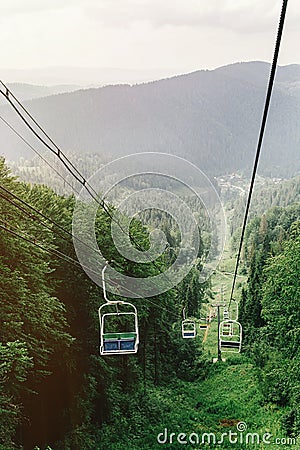 cable hoist chair lift among woods view to top of mountain, summer travel explore concept, amazing scenery Stock Photo