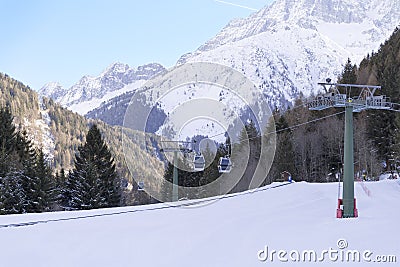 Cableway lift cable cars, gondola cabins on winter snowy mountains background beautiful scenery. Stock Photo