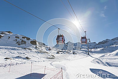 Cableway lift cable cars, gondola cabins on winter snowy mountains background beautiful scenery. Stock Photo