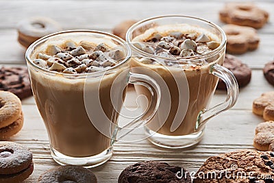 Cacao with marshmallow in cups near cookies on white wooden table. Stock Photo