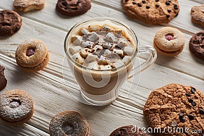 Cacao with marshmallow in mug near cookies on white wooden table. Stock Photo