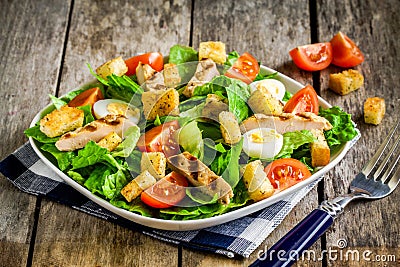 Caesar salad with grilled chicken, croutons, quail eggs and cherry tomatoes Stock Photo