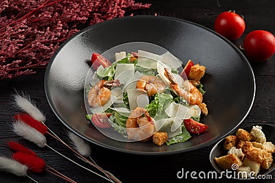 Caesar salad with shrimp on a dark wooden background Stock Photo