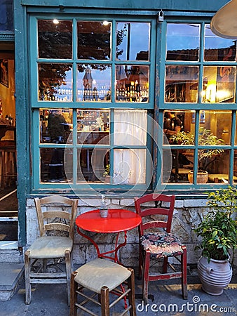 Cafe bar windows door table chairs in the evening in ioannina city greece Editorial Stock Photo