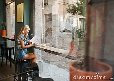 Cafe city lifestyle woman sitting in trendy urban cafe reading m Stock Photo