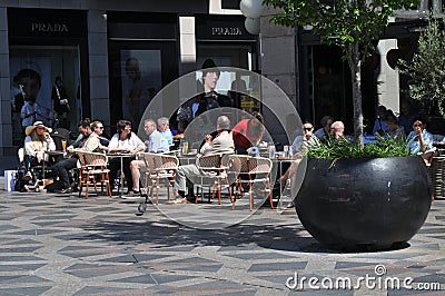 Cafe guests enjoy cold glass ans sun shin in outdoor cafe Editorial Stock Photo