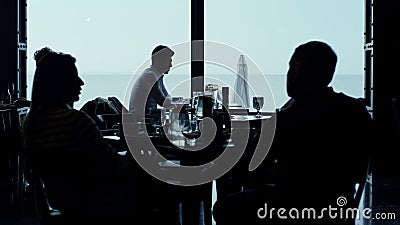 Cafe guests silhouettes resting panoramic lounge bar looking scenic seascape Stock Photo