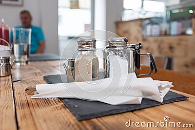 A cafe table setting with a customer relaxing in the background. Editorial Stock Photo
