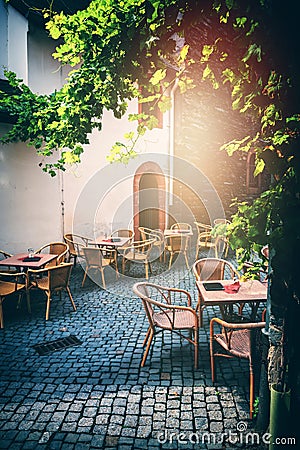 Cafe terrace in small European city at sunny summer day Stock Photo