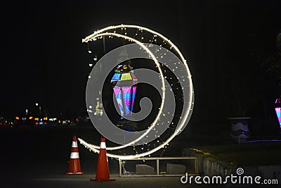 Cairo, Egypt, April 17 2023: A crescent made with led lights with Ramadan Fanous lamp lantern in the street as a festive sign Editorial Stock Photo