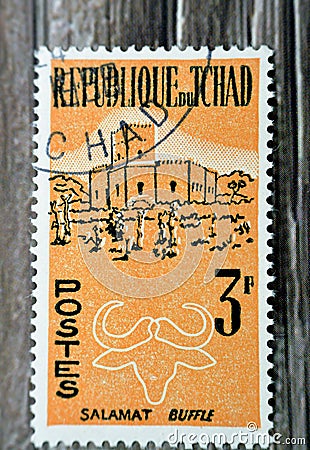 Old used postage stamp printed in Chad, shows Salamat and buffalo, circa 1961isolated on wooden background Editorial Stock Photo