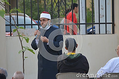 A mosque preacher Imam performs Eid Al Fitr Khutbah (sermon) in an open air space Editorial Stock Photo