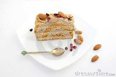 Cake with berries and almonds on a white plate with a Golden spoon. A tasty treat for tea. Stock Photo