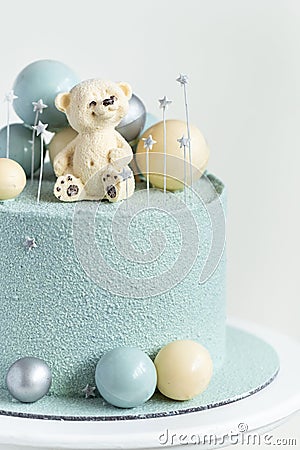 Cake with blue or turquoise velvet cream coating with teddy bear on top. Birthday cake for a little baby with chocolate turquoise Stock Photo