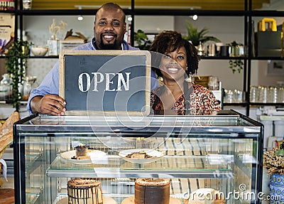 Cake cafe owners with open sign Stock Photo