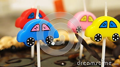 Colorful candles on the cake in the form of cars. Stock Photo
