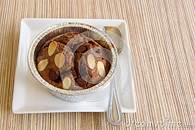 Cake chocolate brownie in a foil cup on wooden table. Stock Photo