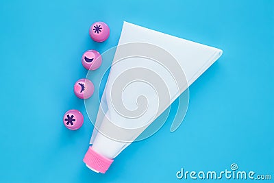 Cake decorating tools on blue background. White pastry bag with pink plastic nozzles for decoration baking Stock Photo