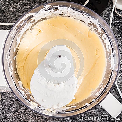 Cake dough or batter in a kitchen mixer bowl, yellow and tasty. Stock Photo