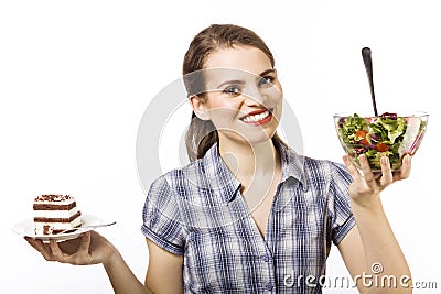 Cake or salad - that is the question. Beautiful young girl with a difficult choice Stock Photo