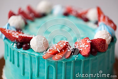 Cake turquoise and blue with strawberries, meringue and candies. Stock Photo