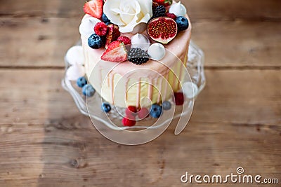 Cake with various berries, figs, meringues and rose on top. Stock Photo