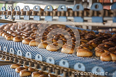 Cakes on automated round conveyor machine in bakery food factory, production line Stock Photo